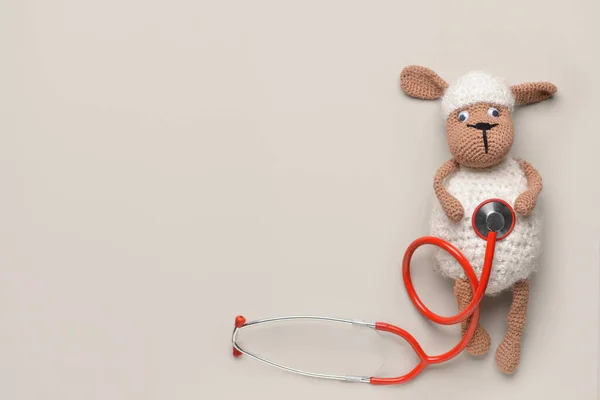 Stethoscope and baby toy on light background — Stock Photo, Image