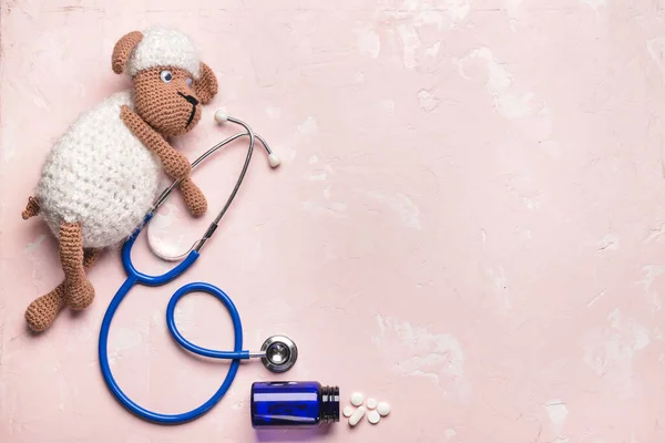 Stethoscope, pills and baby toy on color background — Stok fotoğraf
