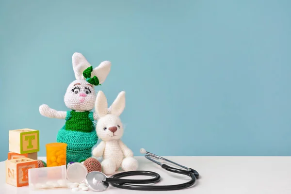 Stethoscope, pills and baby toy on table — Stock Photo, Image
