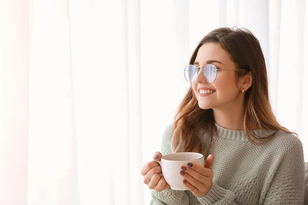 Giovane donna in maglione caldo bere tè a casa — Foto Stock