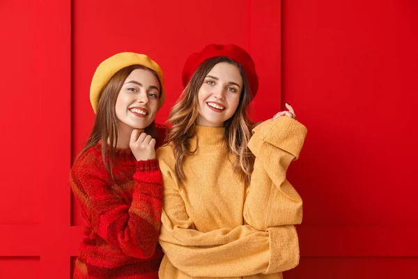 Mladé ženy v teplé svetry na barevném pozadí — Stock fotografie