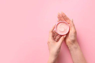 Arkaplanda krema kavanozu olan kadın elleri