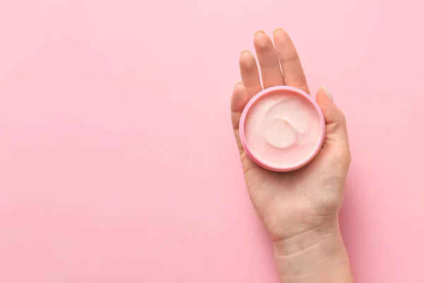 Female hand with jar of cream on color background — Stock Photo, Image