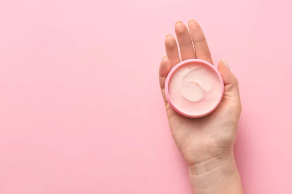 Mão feminina com frasco de creme no fundo de cor — Fotografia de Stock