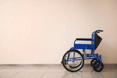 Işık duvarının yanındaki boş tekerlekli sandalye.