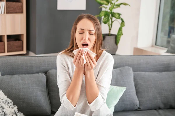 Ung kvinde, der lider af allergi hjemme - Stock-foto