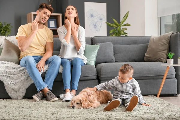 Niño pequeño con perro y sus padres que sufren de alergia a las mascotas en casa — Foto de Stock