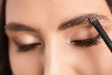 Makyaj sanatçısı genç ve güzel bir kadınla çalışıyor.