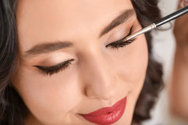 Maquiagem artista trabalhando com bela jovem mulher, close-up — Fotografia de Stock