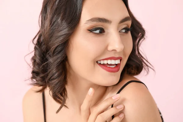 Hermosa mujer joven con maquillaje elegante en el fondo de color — Foto de Stock