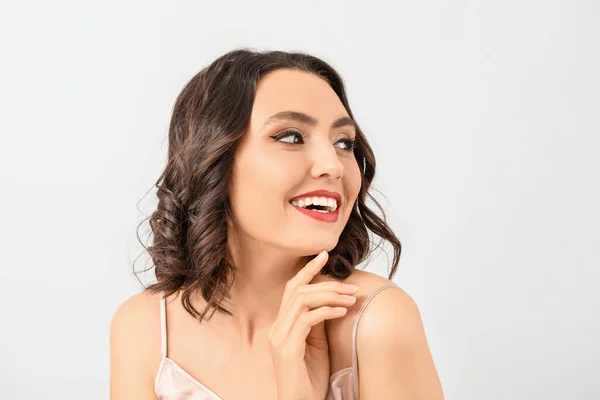 Krásná mladá žena se stylovým make-upem na světlém pozadí — Stock fotografie