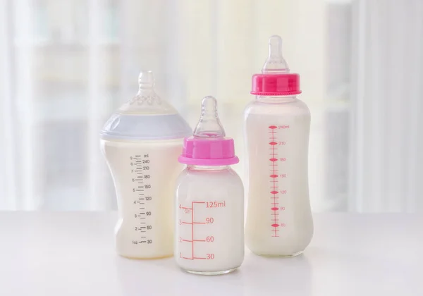 Bottles of milk for baby on table indoors