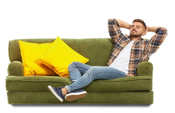 Ung man avkopplande på soffan mot vit bakgrund — Stockfoto