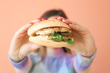 Burgeri olan genç bir kadın, yakın plan.