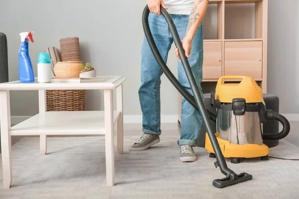 Giovane asiatico uomo hoovering pavimento a casa — Foto Stock