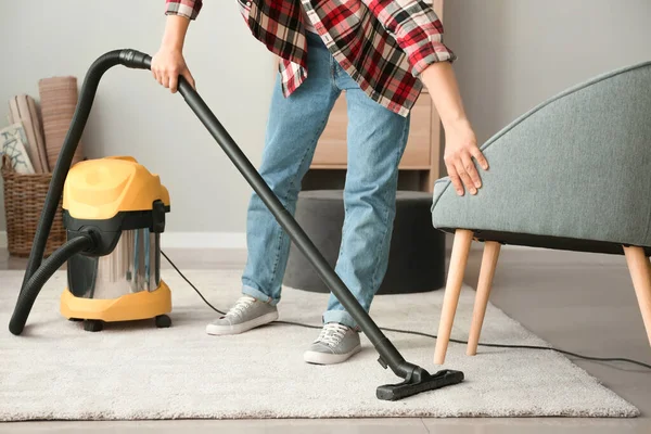 Giovane asiatico uomo hoovering pavimento a casa — Foto Stock