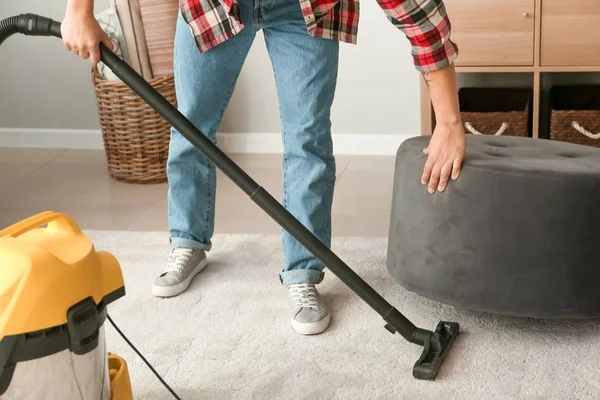 Young Asian man hoovering floor at home — Stock Photo, Image