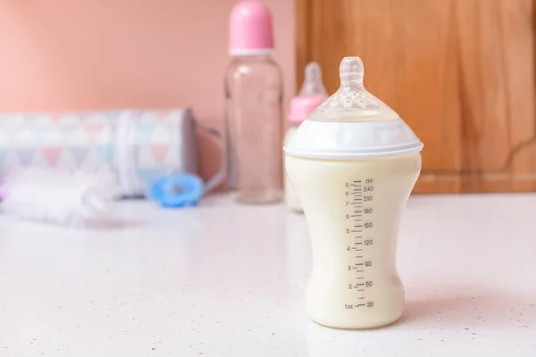 Bottle of milk for baby on white table