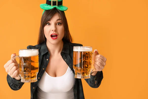 Funny young woman with beer on color background. St. Patrick\'s Day celebration