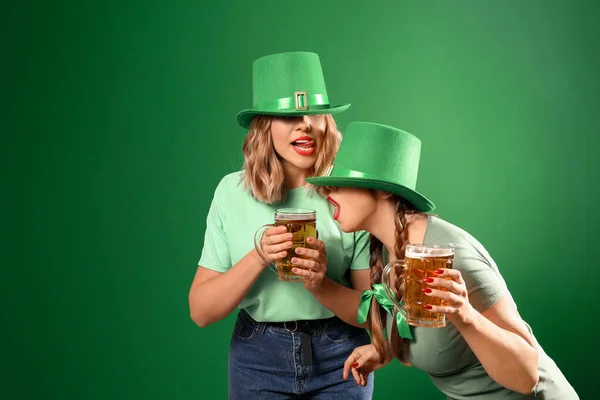 Grappige jonge vrouwen met bier op gekleurde achtergrond. St. Patrick 's Day viering — Stockfoto