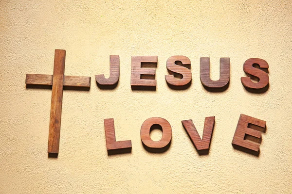 Christian cross and text JESUS LOVE on color background — Stock Photo, Image
