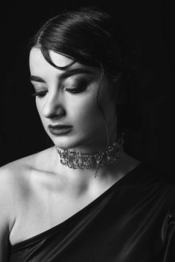 Black and white photo of beautiful fashionable woman on dark background