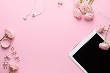 Pembe arka planda tablet bilgisayarlı, çiçekli ve kozmetik ürünlü kompozisyon