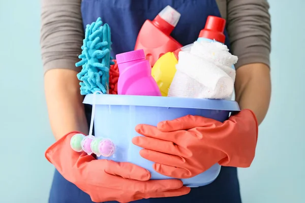 Уборщик с набором чистящих средств на цветном фоне, крупным планом — стоковое фото