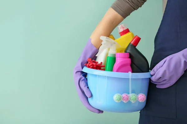 Janitor with set of cleaning supplies on color background — 스톡 사진