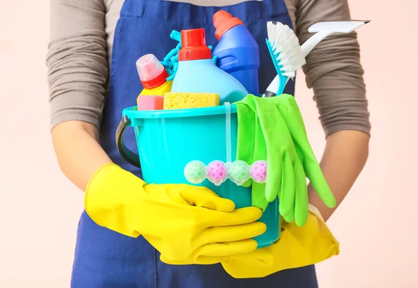 Janitor with set of cleaning supplies on color background, closeup — 스톡 사진