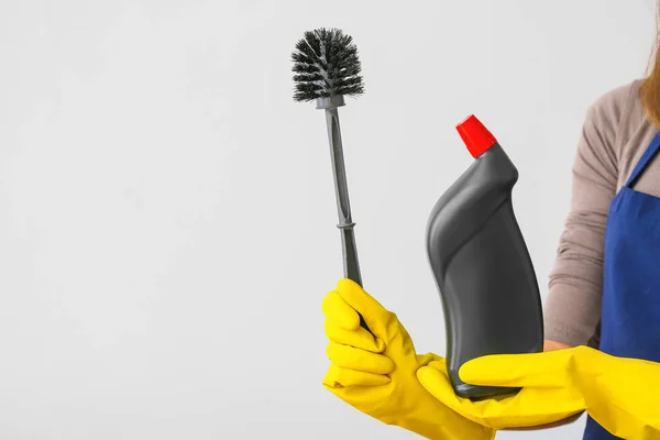 Janitor with detergent and toilet brush on light background — 스톡 사진