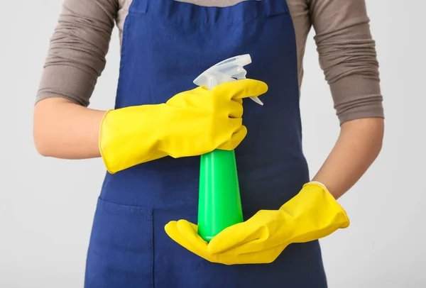 Janitor with detergent on light background — Stock Photo, Image