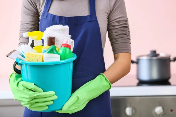 Janitor with set of cleaning supplies in kitchen — Stock Photo, Image