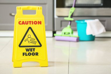 Mutfakta ıslak zeminde uyarı işareti var.