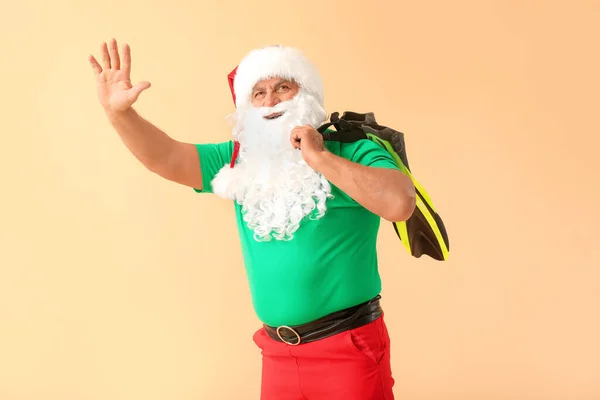 Santa Claus s pádly na barevném pozadí. Koncept dovolené — Stock fotografie