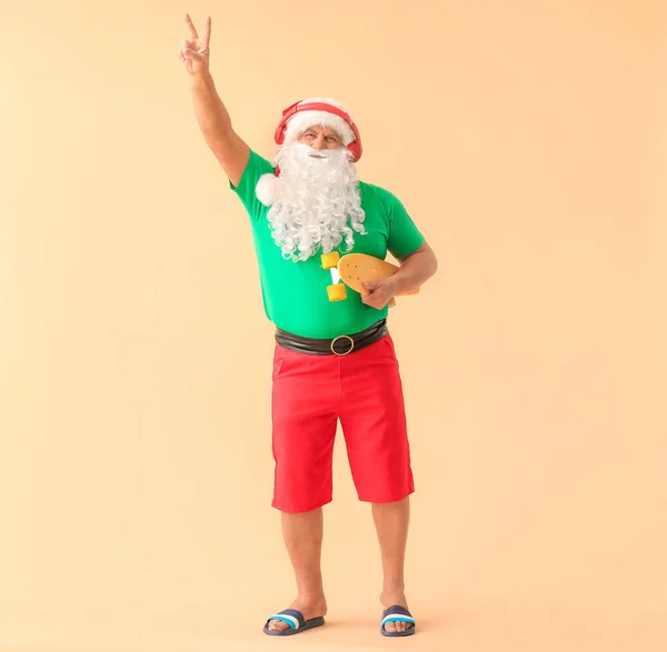 Santa Claus with skateboard on color background. Concept of vacation — Stock Photo, Image