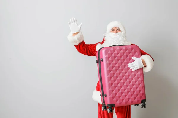 Санта Клаус з багажем на світлому тлі. Концепція відпустки — стокове фото