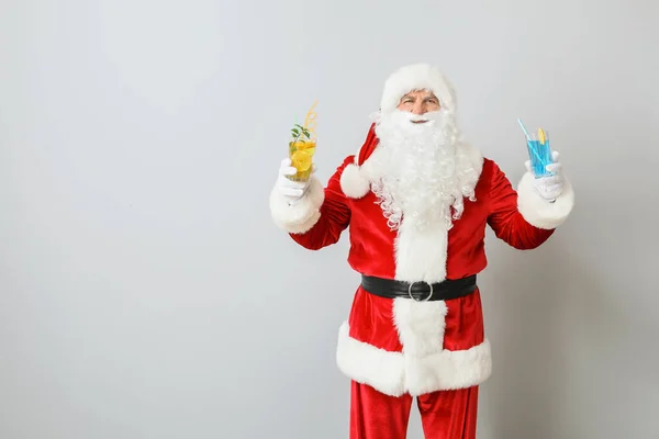 Święty Mikołaj z koktajlami na jasnym tle. Pojęcie urlopu — Zdjęcie stockowe