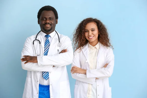 African-American doctors on color background — Stock Photo, Image