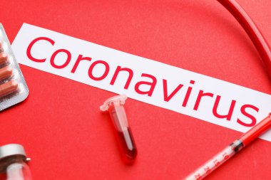 Kan örneği içeren test tüpü ve renk arkaplanı üzerine Coronavirus metni