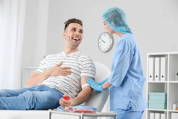 Female doctor preparing male donor for blood transfusion in hospital — Stock Photo, Image
