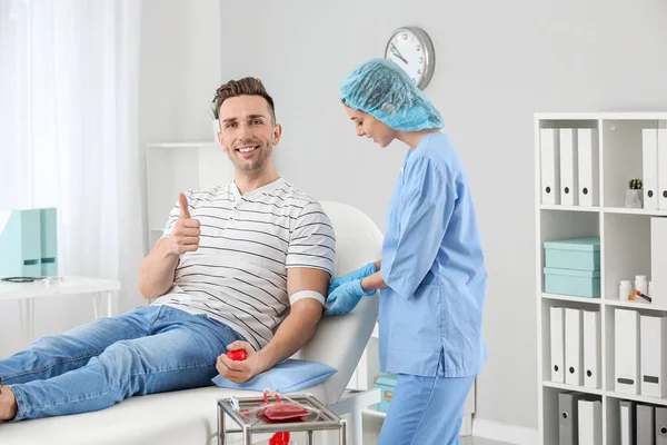Doctora preparando donante masculino para transfusión de sangre en el hospital —  Fotos de Stock