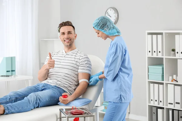 Female doctor preparing male donor for blood transfusion in hospital — Stock Photo, Image