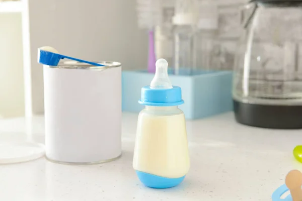 Lahvička kojeneckého mléka na stole uvnitř — Stock fotografie