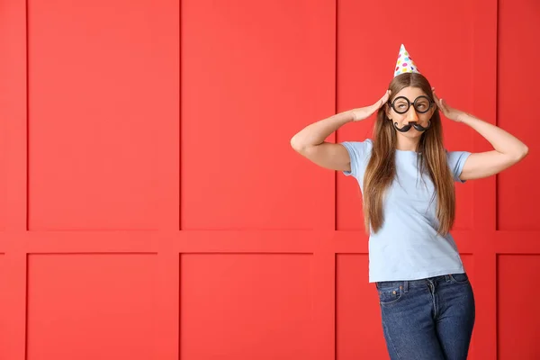 Woman in funny disguise on color background. April fools' day celebration — Stock Photo, Image