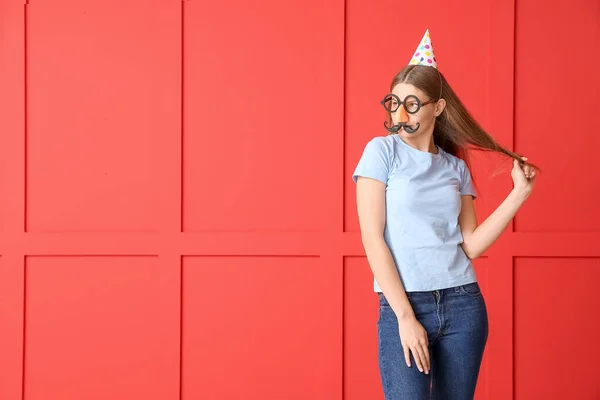Vrouw in grappige vermomming op kleur achtergrond. 1 april dwaze dag viering — Stockfoto