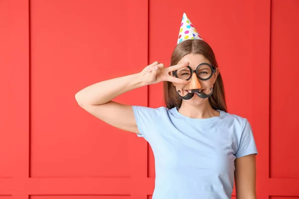 Frau in lustiger Verkleidung auf farbigem Hintergrund. Aprilscherz-Fest — Stockfoto