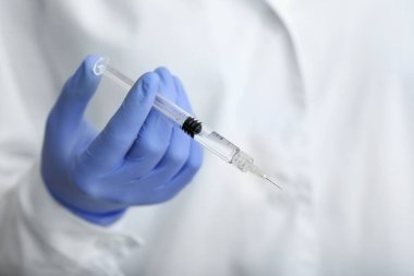 Kozmetik uzmanı şırıngayı enjeksiyon için tutuyor.