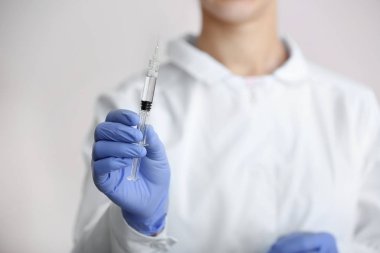 Kozmetik uzmanı şırıngayı enjeksiyon için tutuyor.