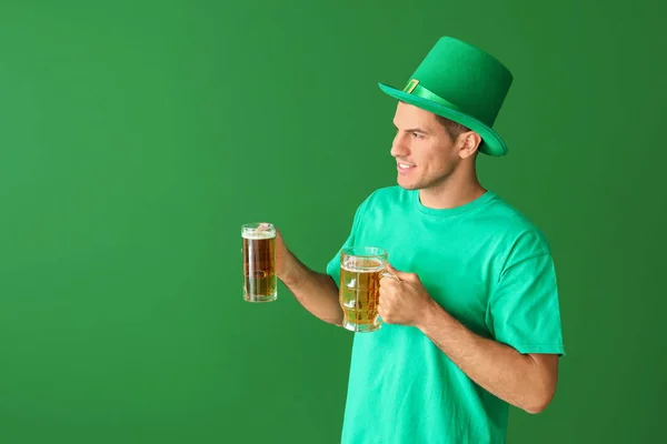Jongeman met bier op kleur achtergrond. St. Patrick 's Day viering — Stockfoto
